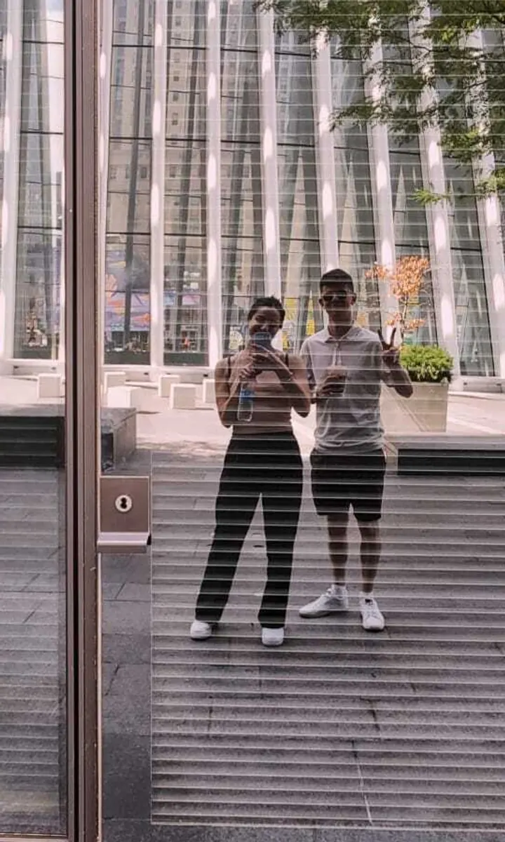 Two members of the Brandbeet team reflected in a city window